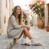 Cream suede fringe hippie sandals worn in a Mediterranean alley