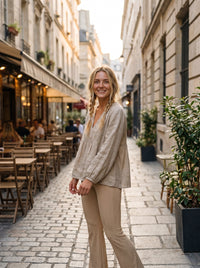 Modelo boho con pantalones acampanados de algodón beige en la ciudad