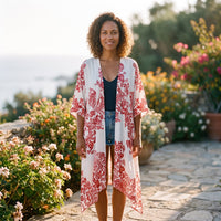 Rød strandkimono med porcelænsprint båret af smilende model ved havet