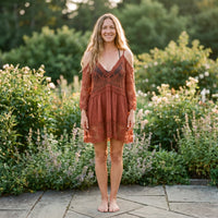 Terracotta strandtunika i blonde båret af en smilende model i en have