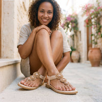 Smiling model wearing the beige beaded medallion hippie sandals