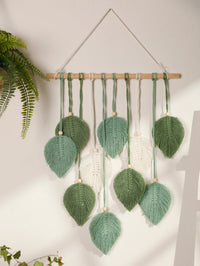 Sage green cotton macrame wall hanging with leaves on wooden branch