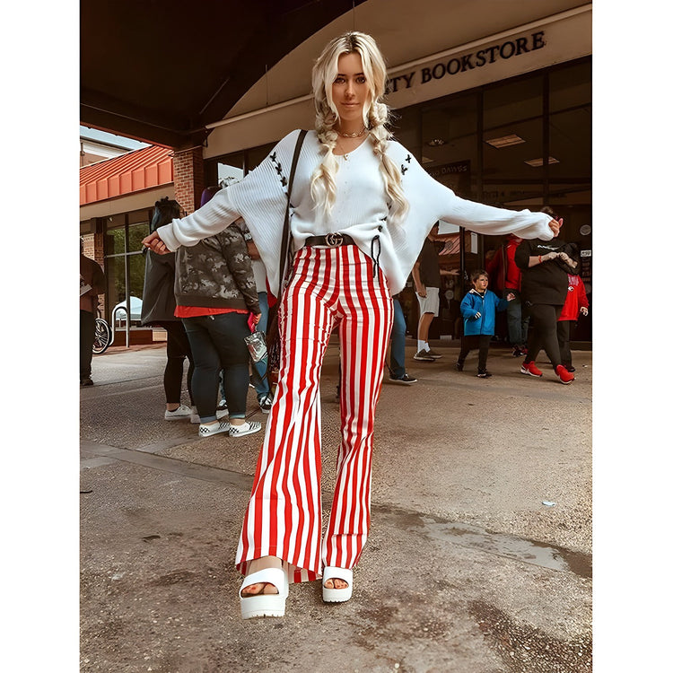Model wearing striped bell bottom pants styled with a fitted top and boots