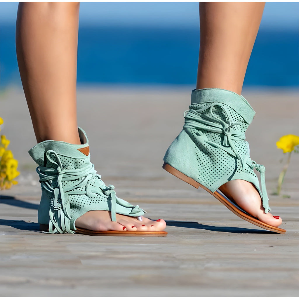 Zeegroene sandalen met franjes gedragen aan zee