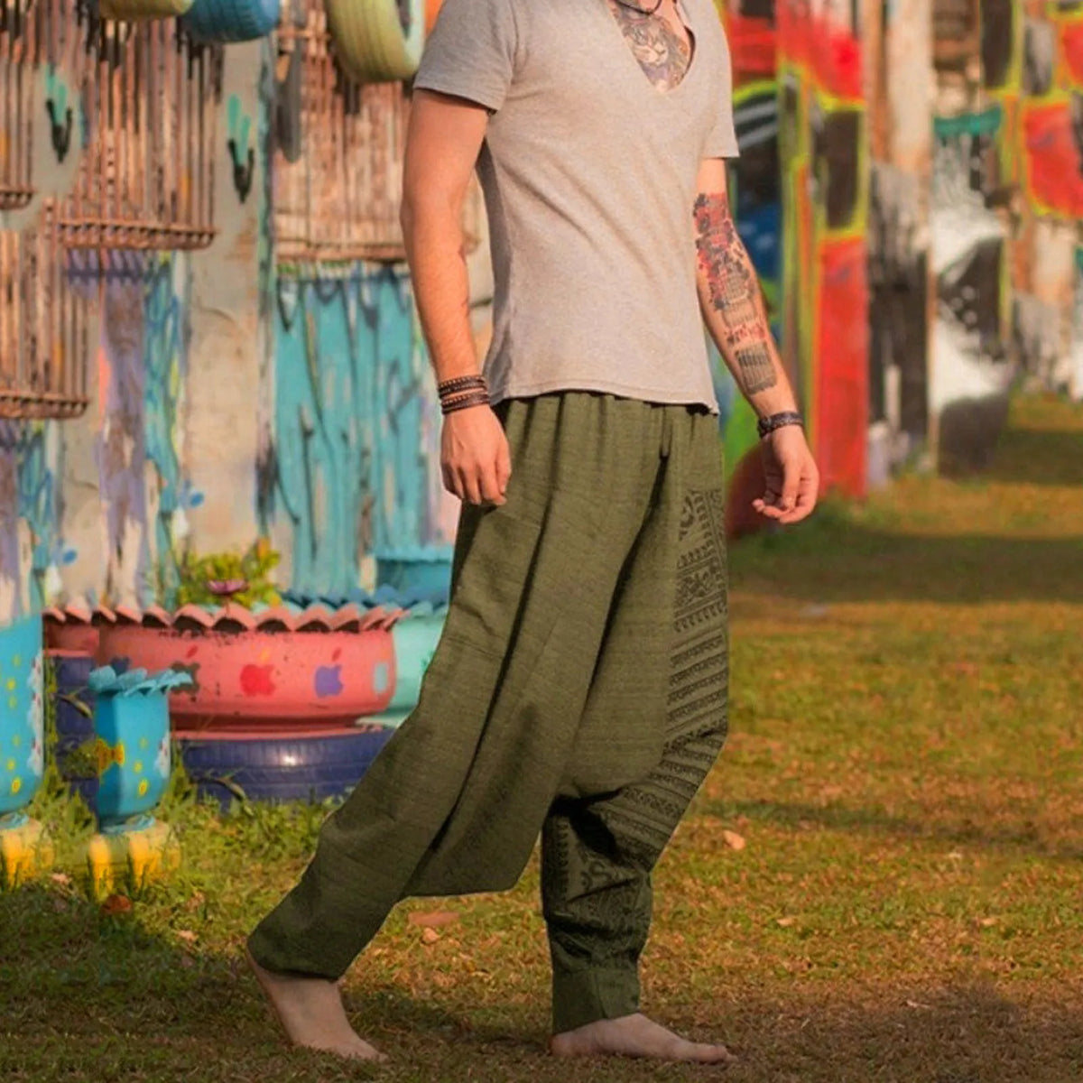 Olive green harem pants worn in motion with printed side panel