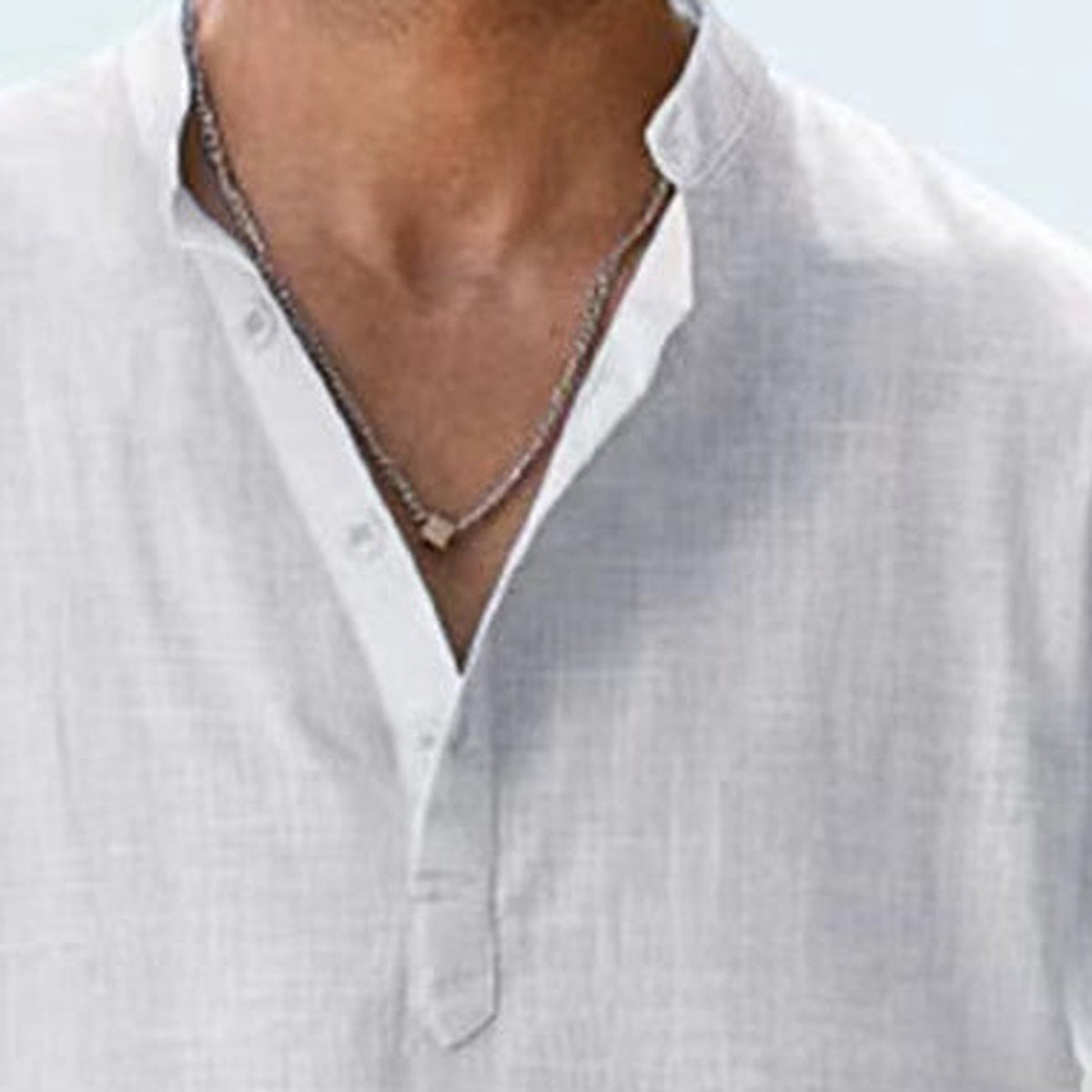 Close-up of the buttoned mandarin collar in white linen