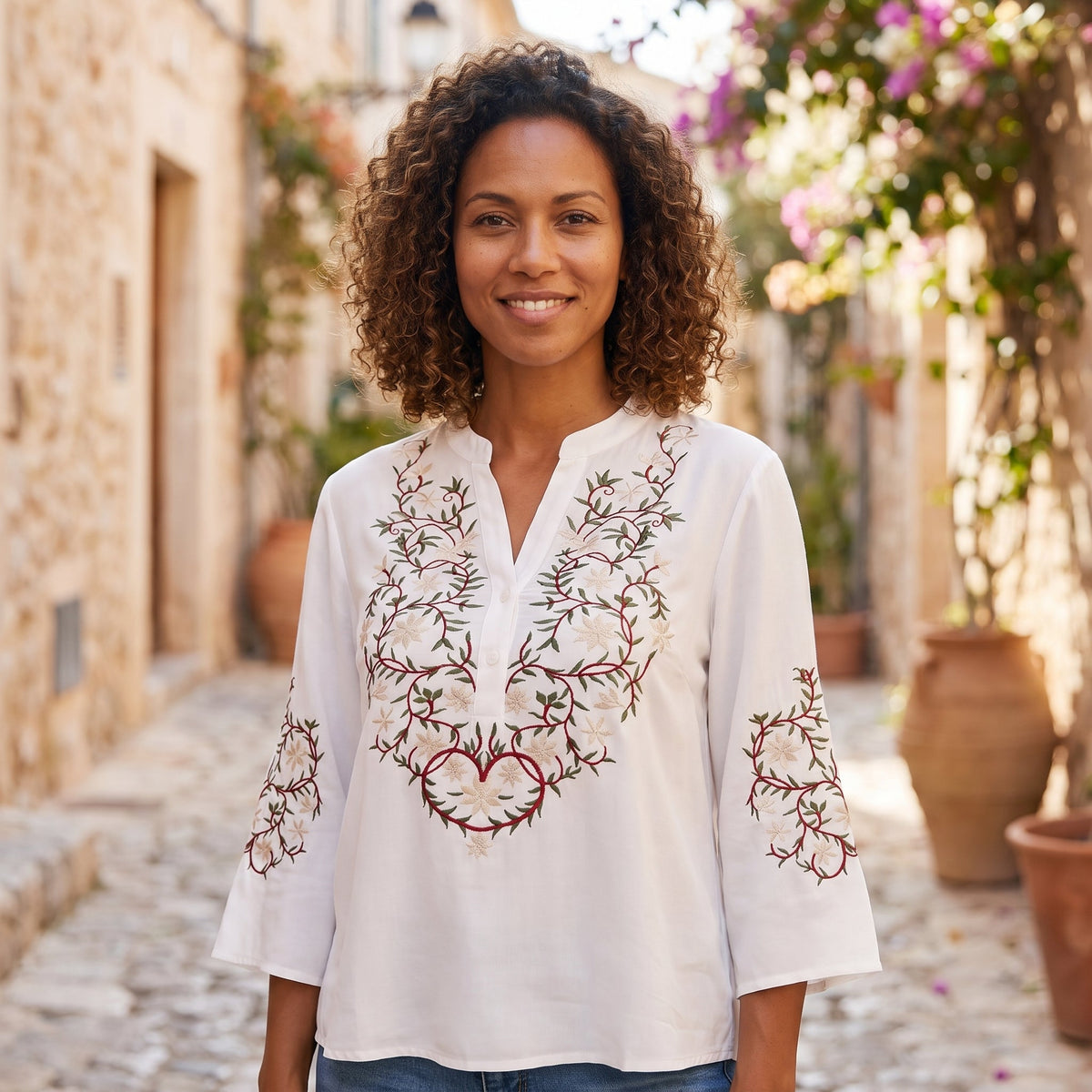 Smiling model wearing the white embroidered boho button down shirt outdoors