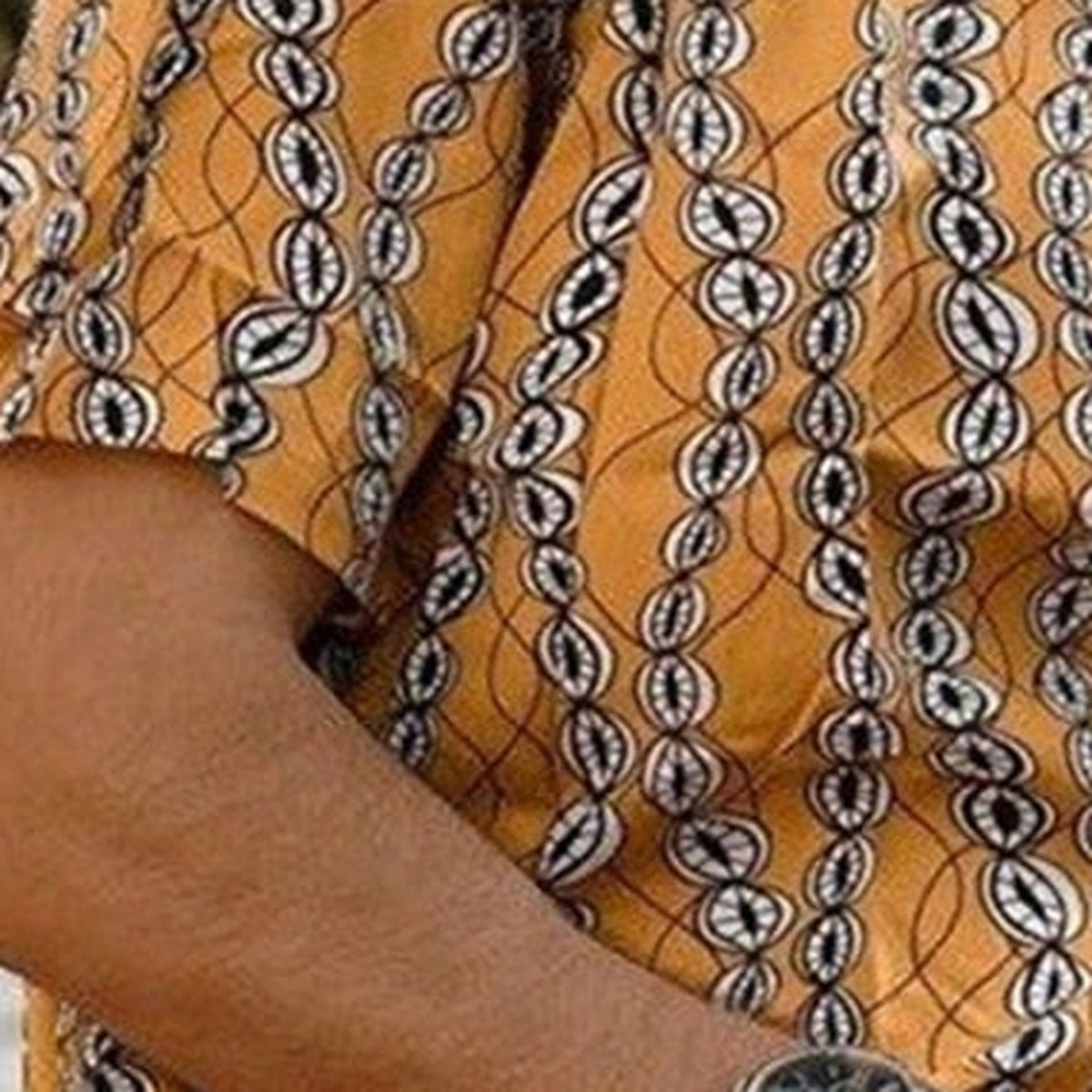 Close-up of the white cowrie shell print on mustard fabric