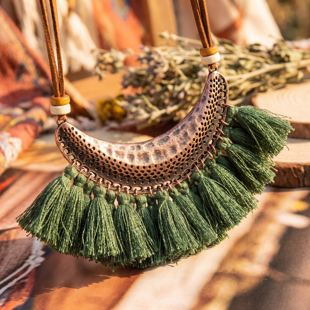 Close-up of the hammered openwork metal crescent and thread fringe