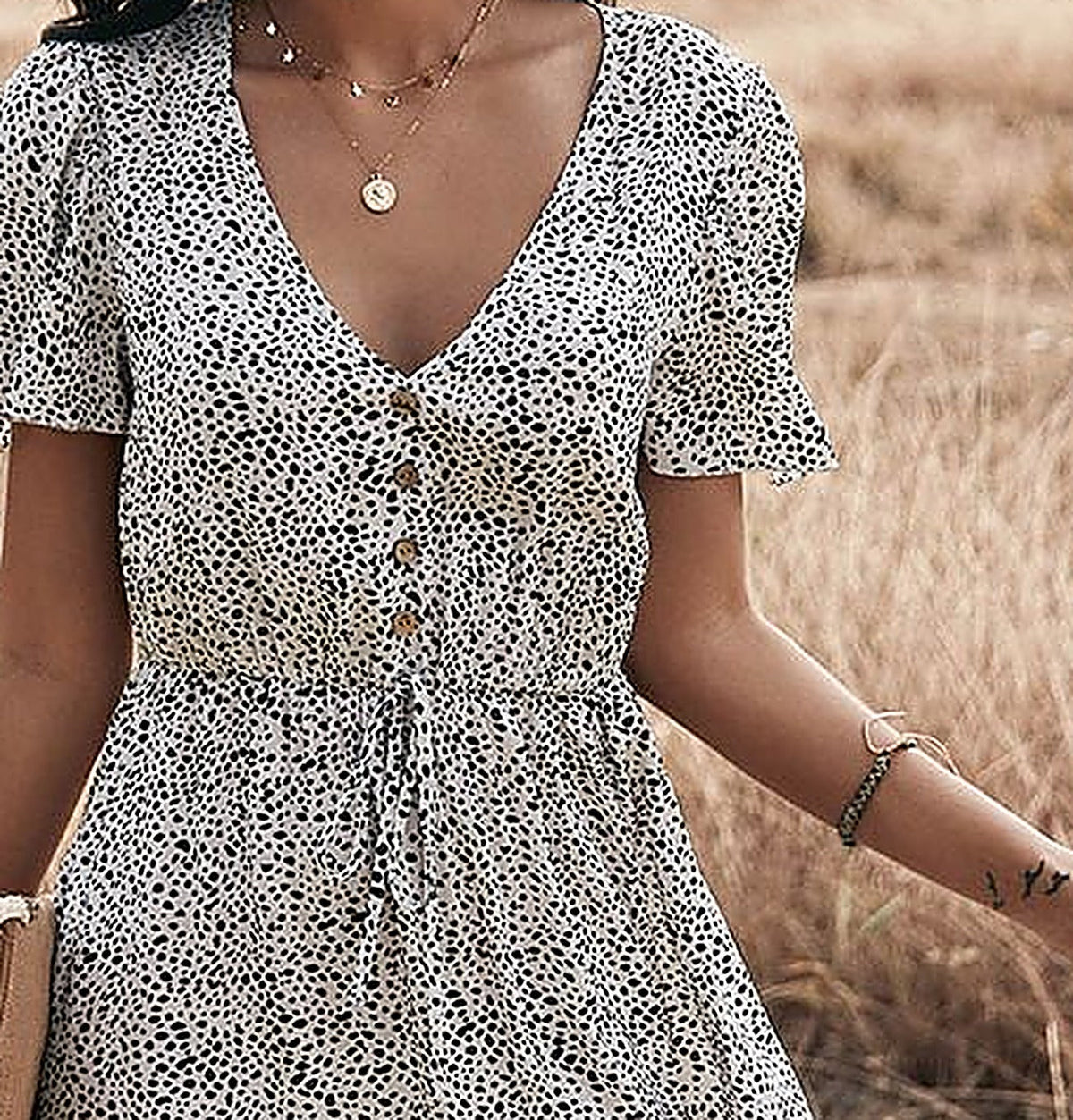 Detail of the buttoned V-neck and waist cord
