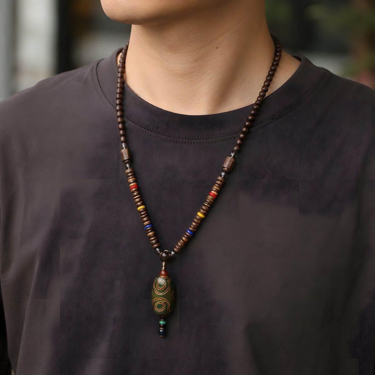 Long wood bead necklace worn over a dark t-shirt