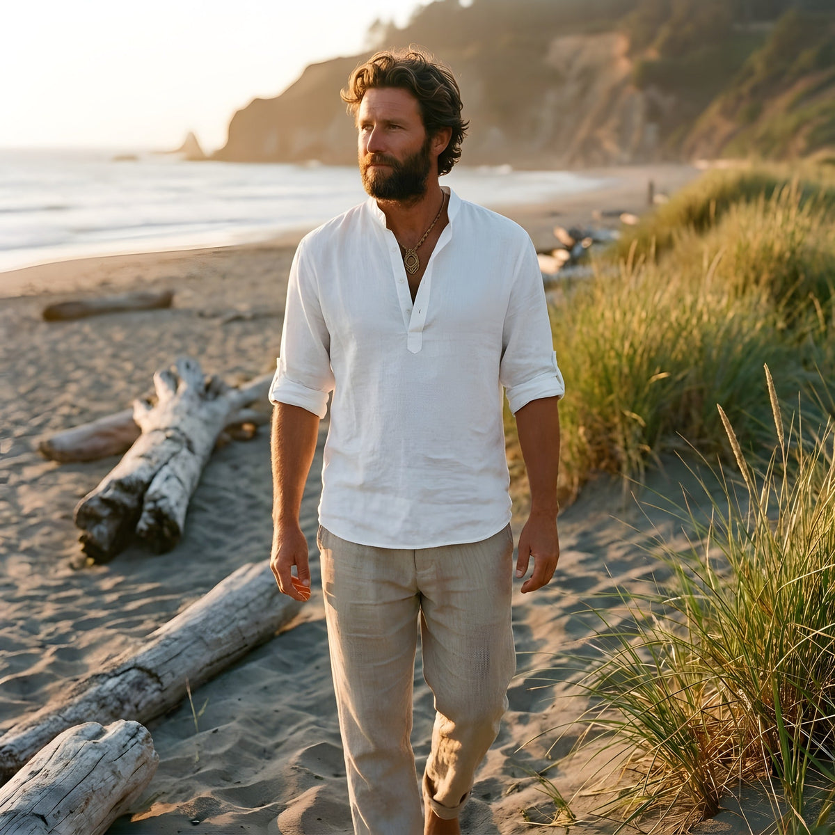 Man walking on the beach in the white linen shirt, sleeves rolled