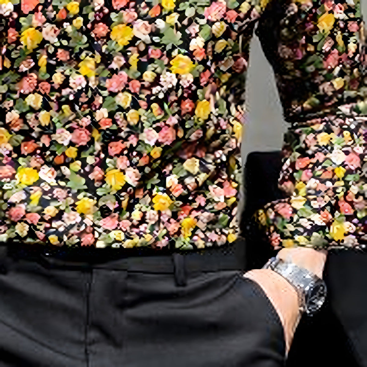 Yellow floral shirt tucked into pants, black ground with yellow flowers
