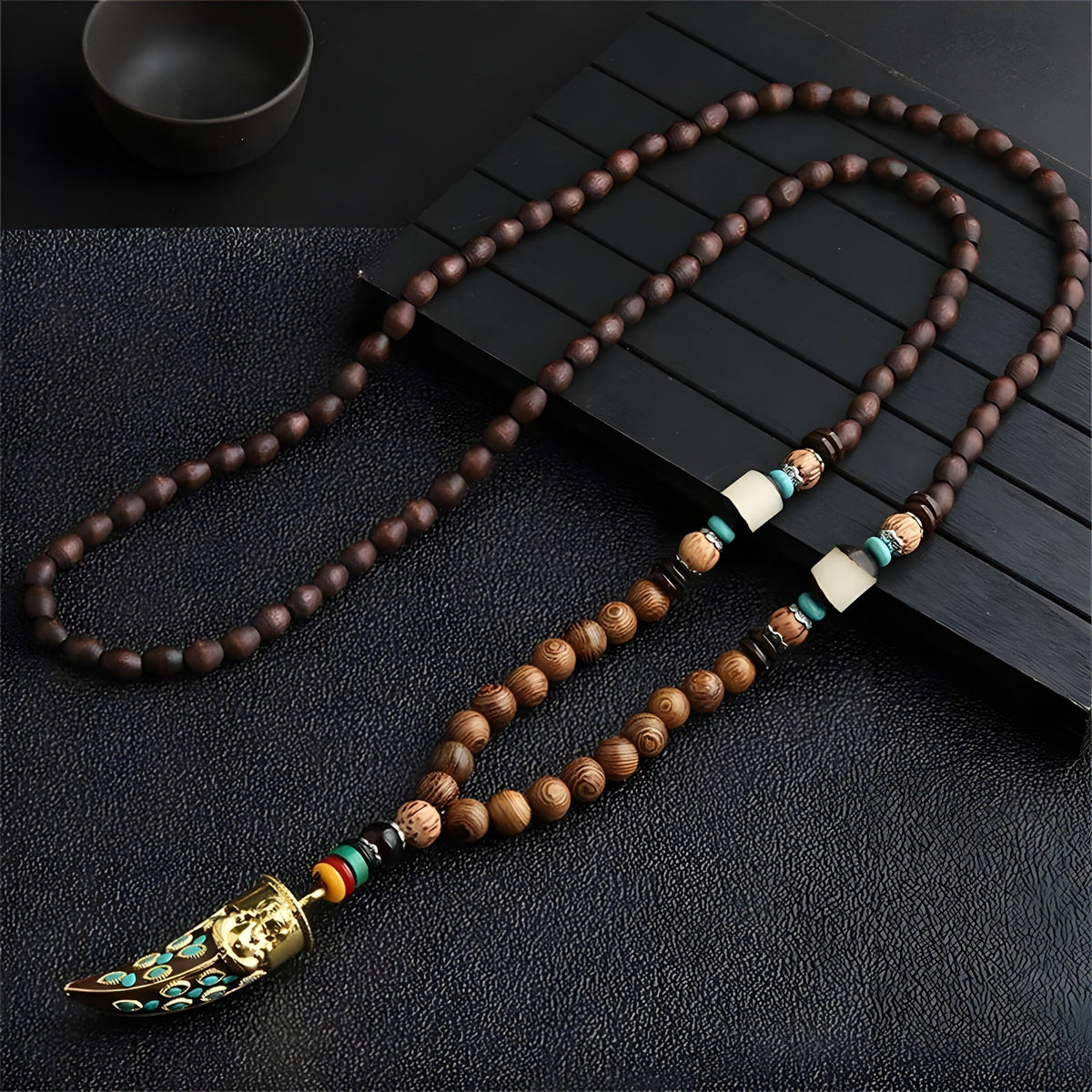 Wood bead necklace with Buddha horn pendant laid flat