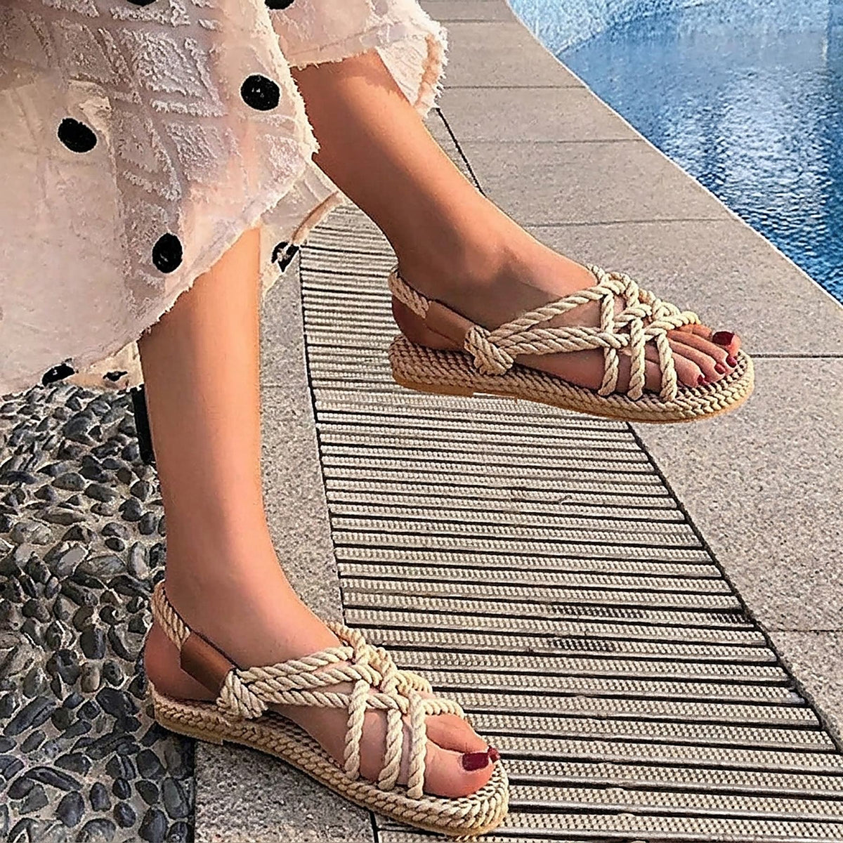 Beige braided rope flat sandals worn by the water