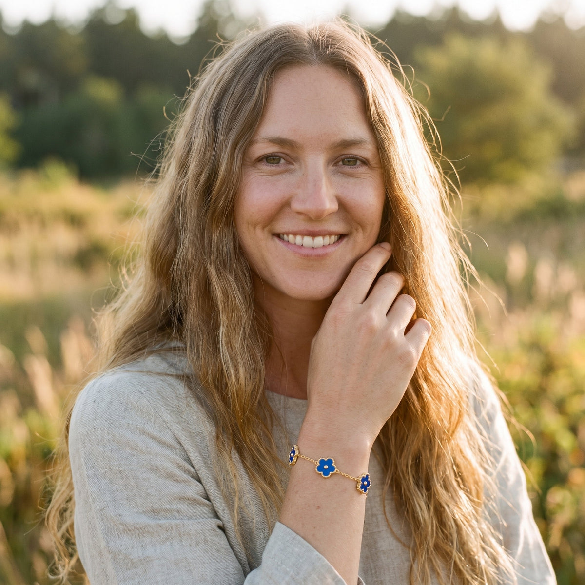 Smiling model wearing the blue flower hippie bracelet in golden light
