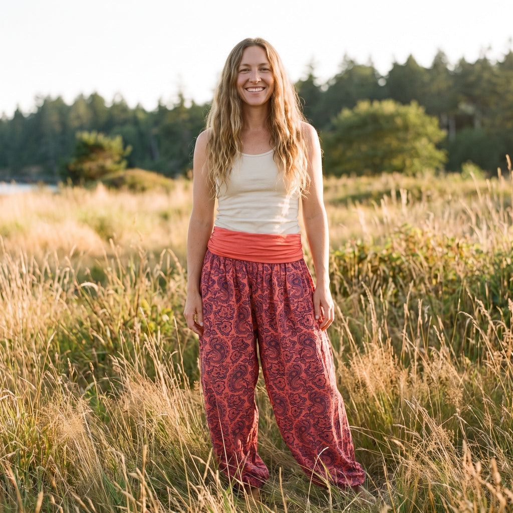 Smiling model wearing the red paisley harem pants outdoors