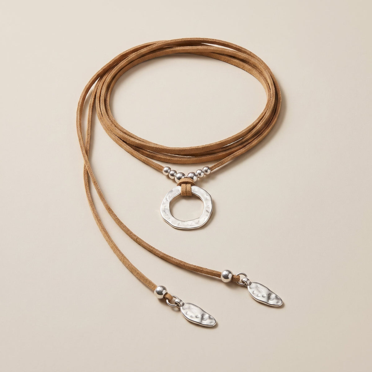 Camel suede cord necklace with hammered silver ring, laid flat