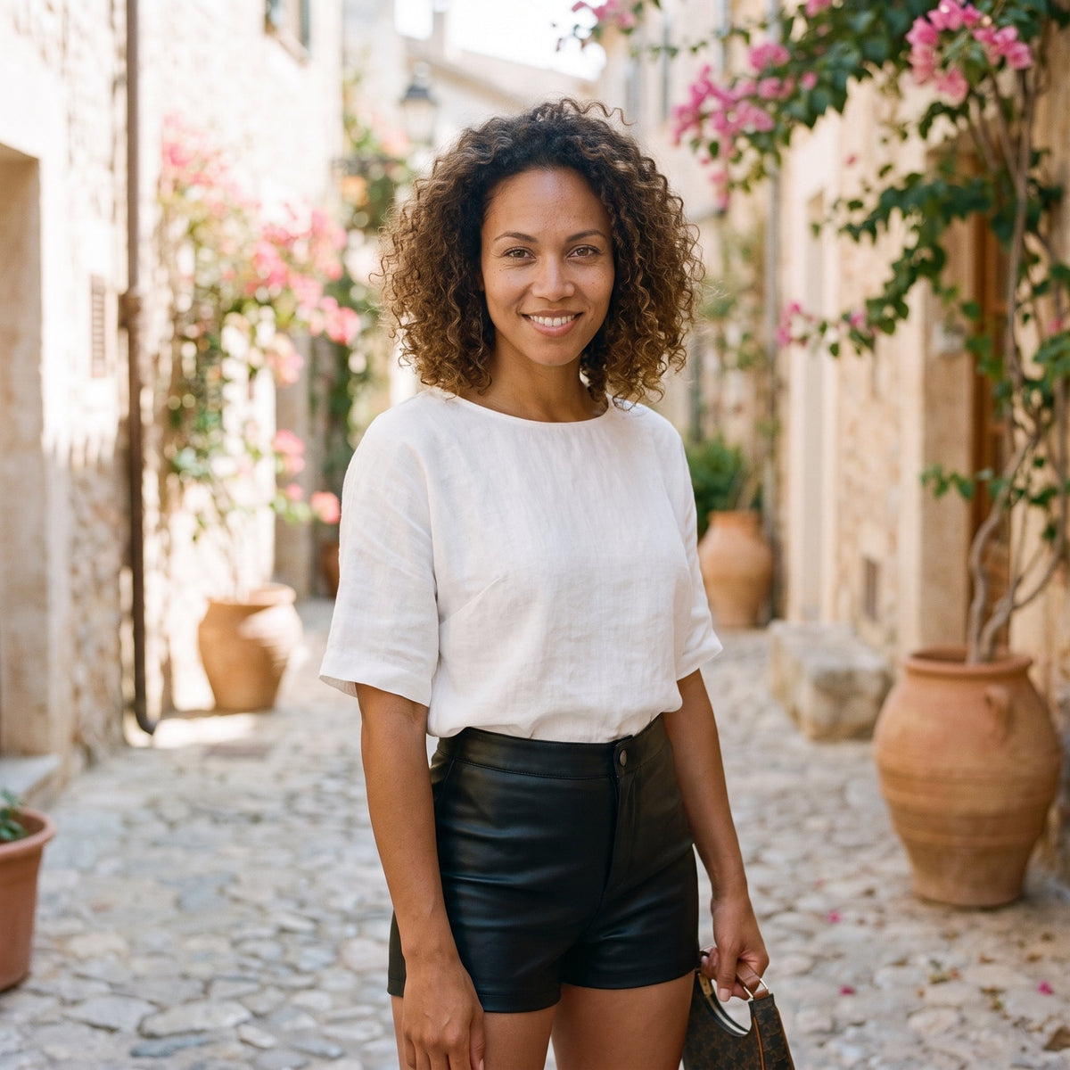 Lächelndes Model in den schwarzen Kunstleder-Shorts mit hoher Taille