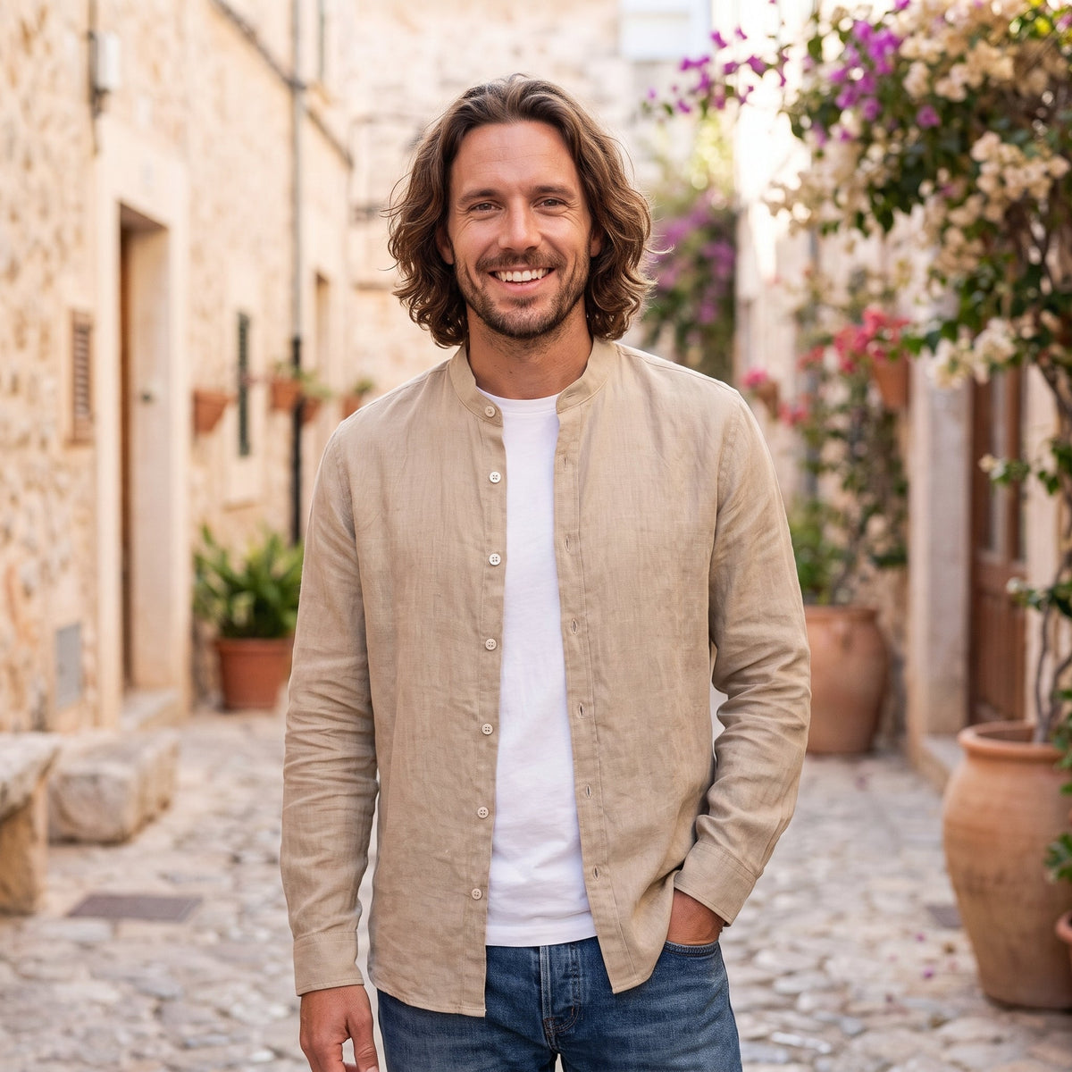 Smiling man wearing beige linen-look hippie shirt in Mediterranean alley