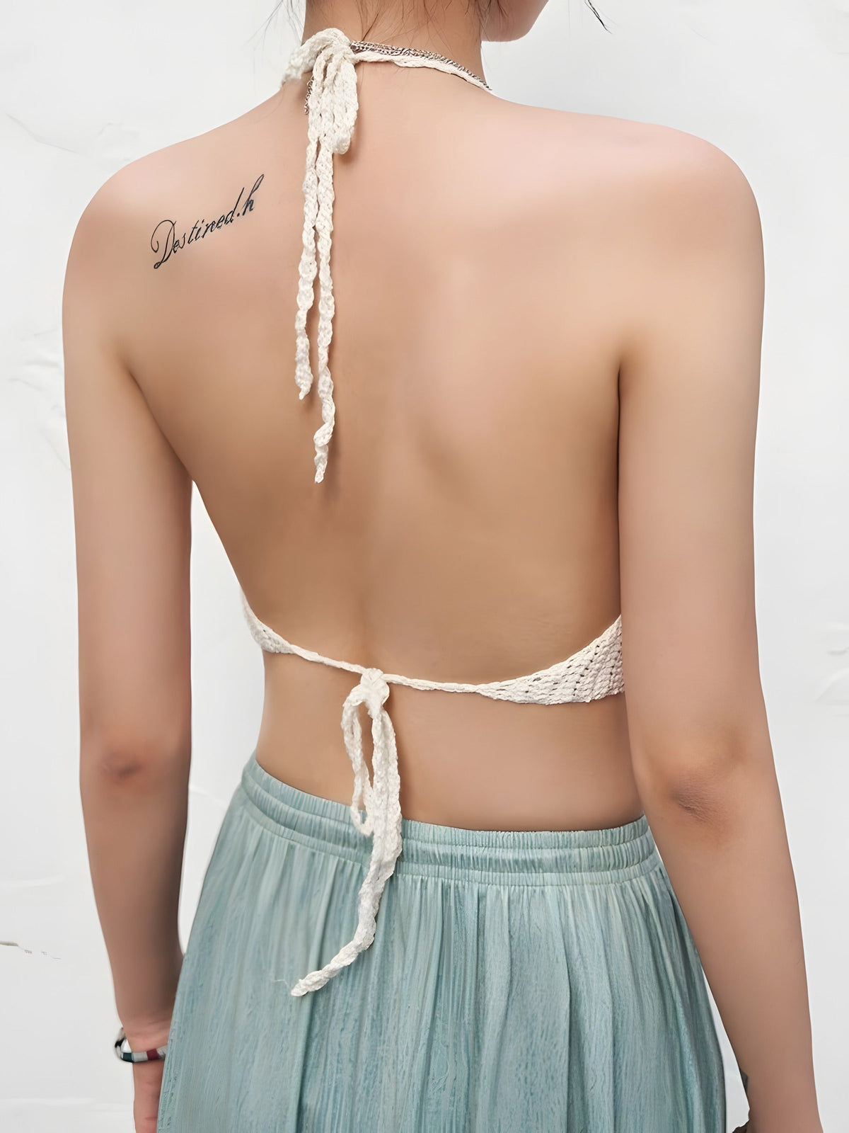 White crochet crop top worn from behind, open back ties
