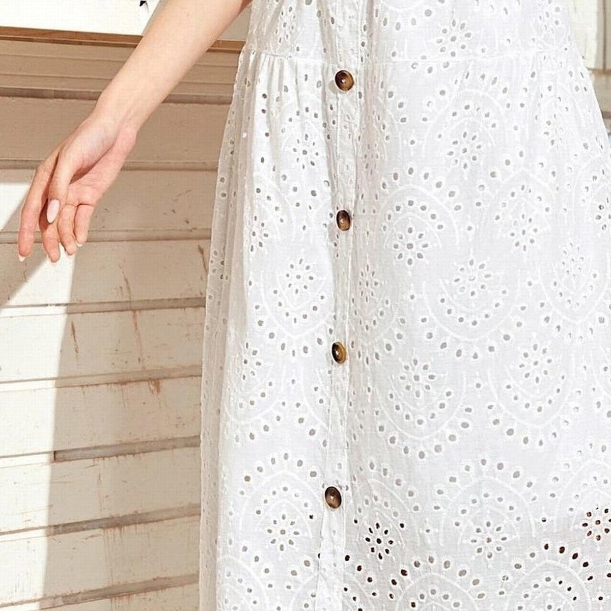 Close-up of the openwork eyelet lace and wooden buttons