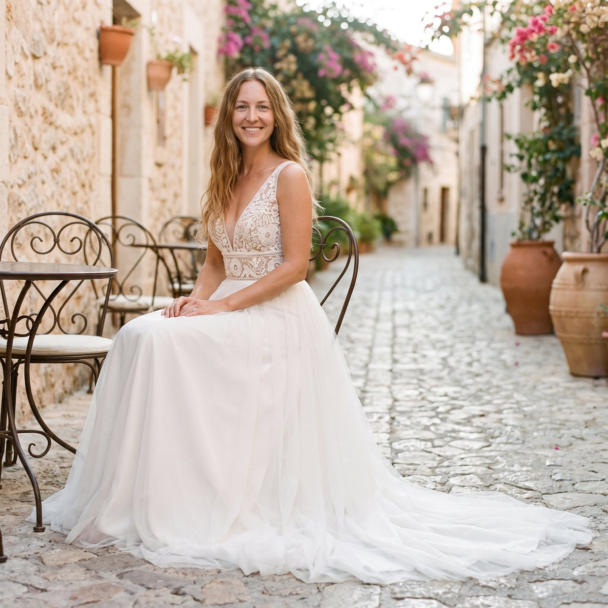 Smiling model in tulle wedding dress on Mediterranean terrace