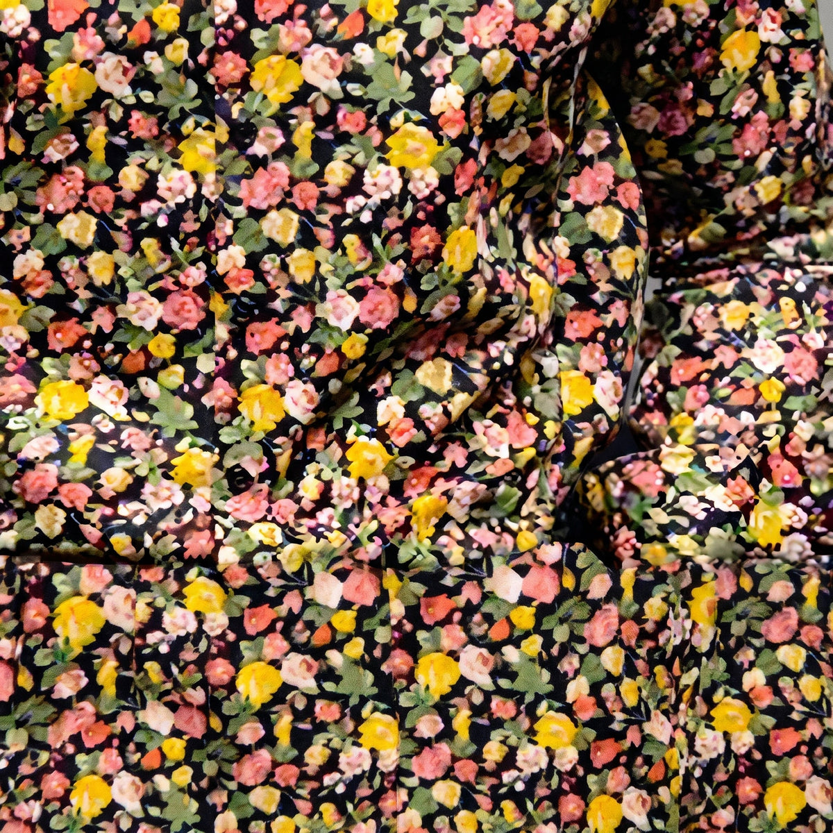 Close-up of the 70s floral print, yellow and pink blooms on black