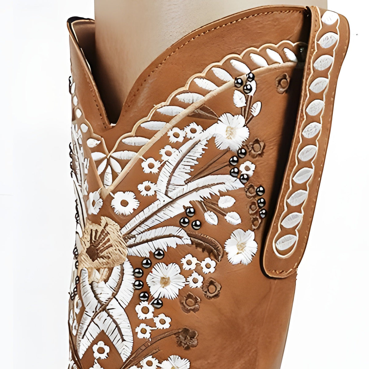 Close-up of the white floral embroidery and studs on camel leather