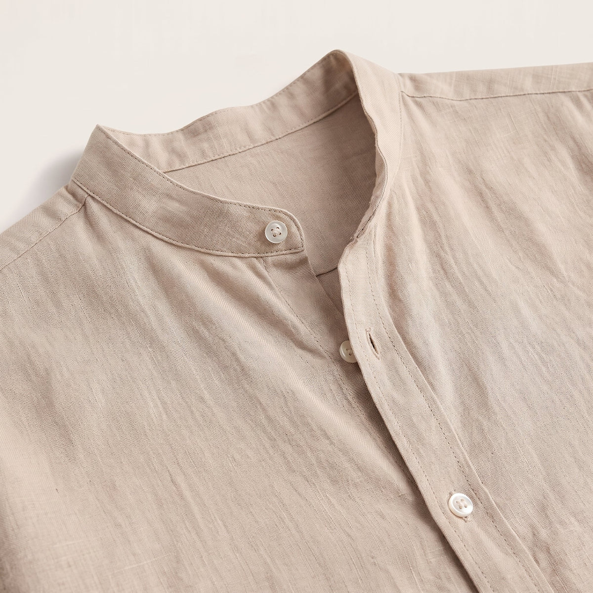 Close-up of mandarin collar and beige linen-look fabric