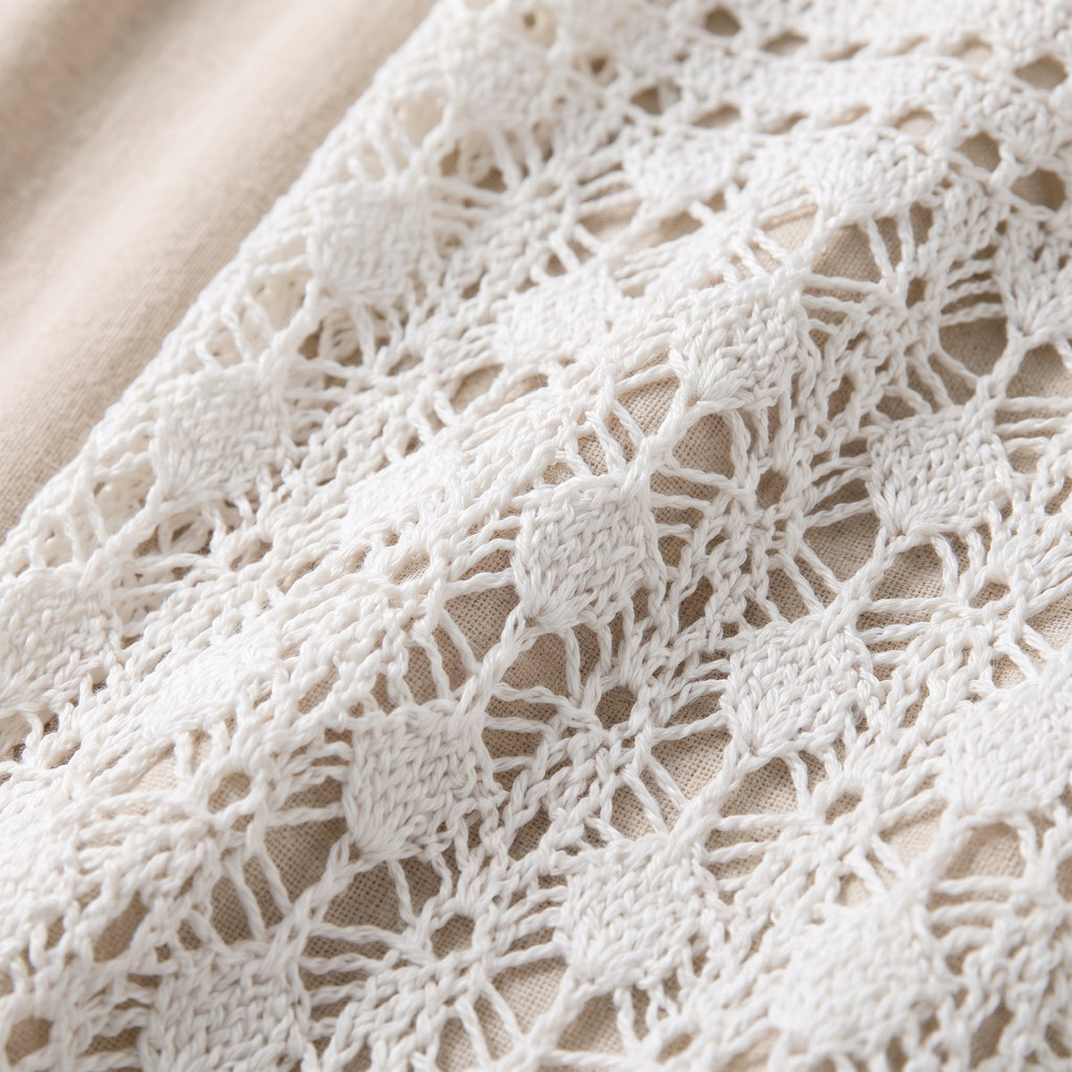 Close-up of the open-work crochet pattern and fringe