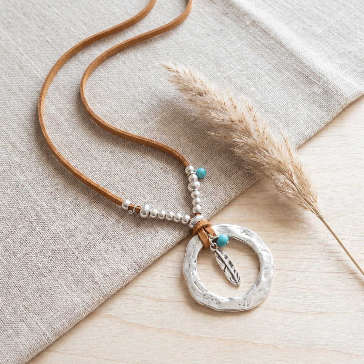 Flat lay of the silver ring pendant and turquoise bead