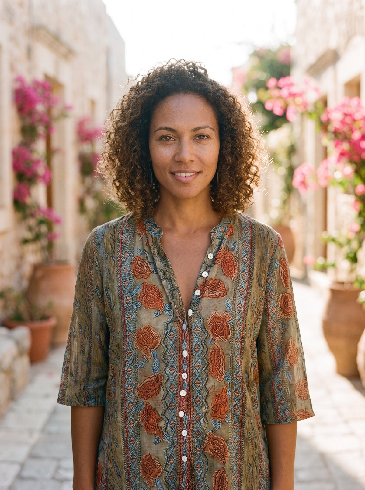 Smiling model wearing the beige floral boho button down shirt