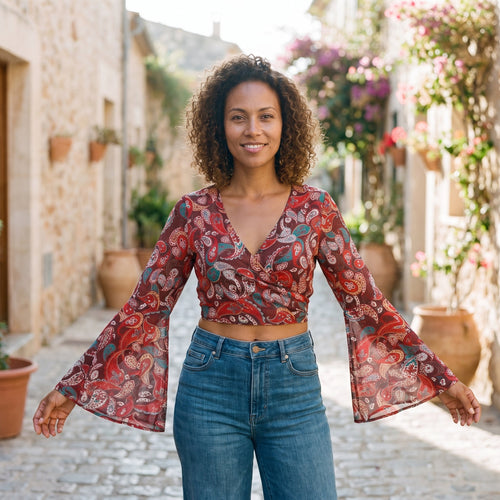 Smiling model wearing the red paisley 70s boho wrap crop top