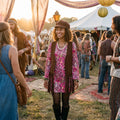 Mujer con el disfraz hippie rosa de flecos y el sombrero a juego