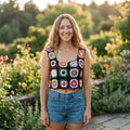 Schwarzes Granny-Square-Häkel-Crop-Top, von lächelndem Model im Garten getragen