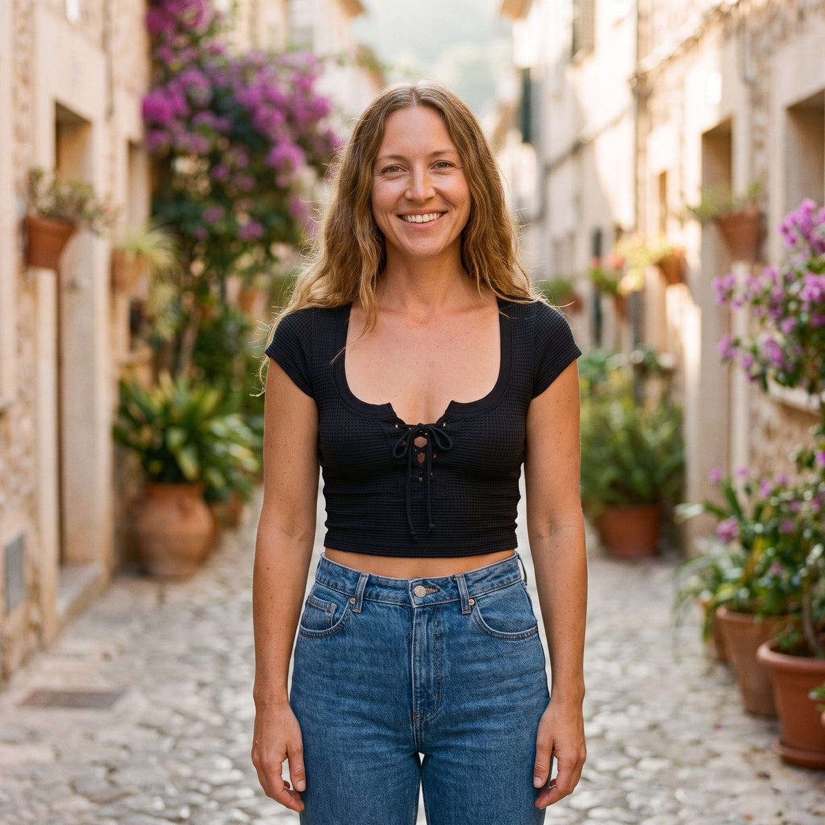 Black waffle knit lace-up boho crop top worn by a smiling model