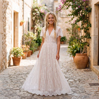 Smiling model wearing the white lace boho wedding dress in an alley