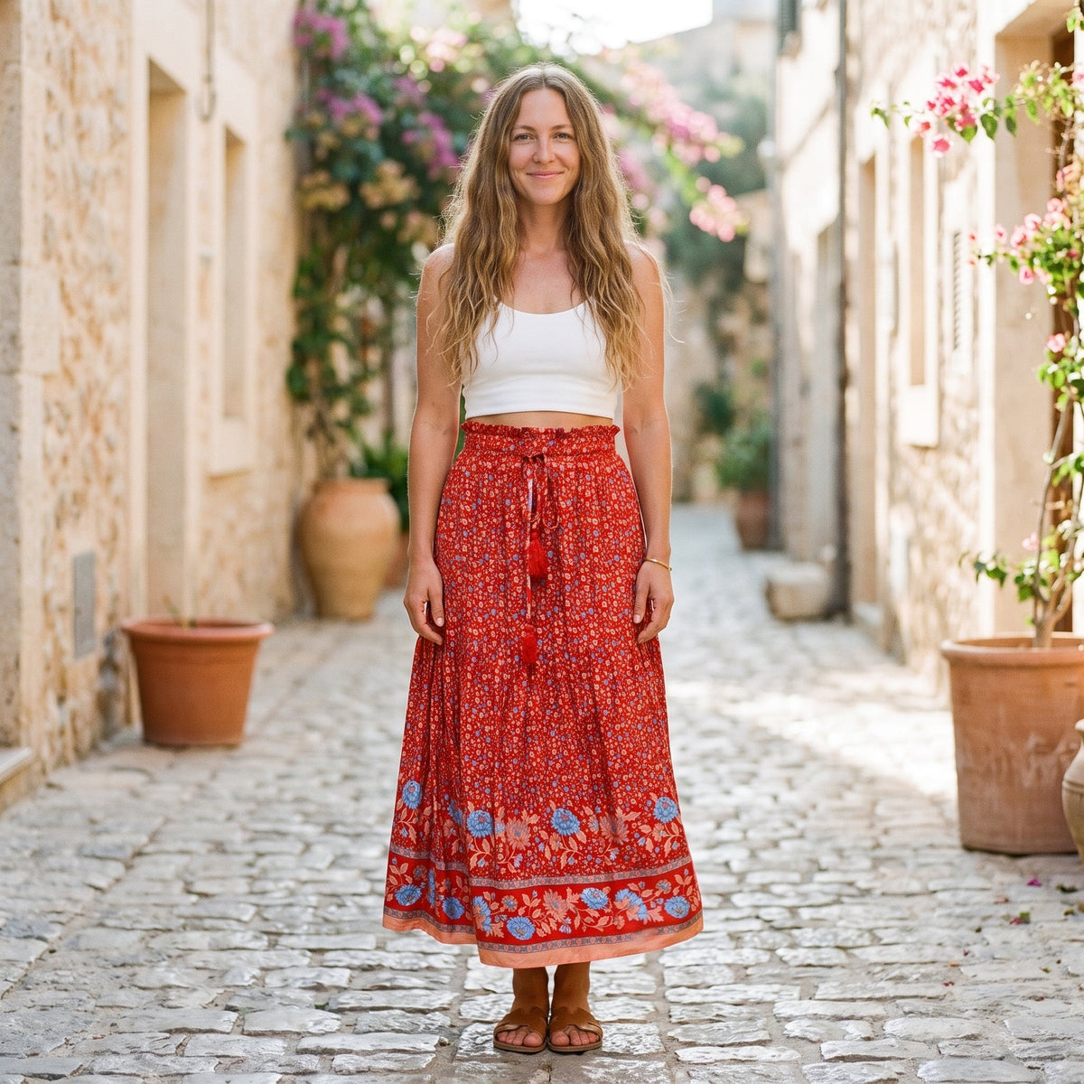 Rød blomstret boho midinederdel båret af en smilende model