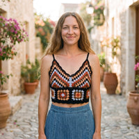 Black chevron crochet crop top worn by a smiling model in an alley