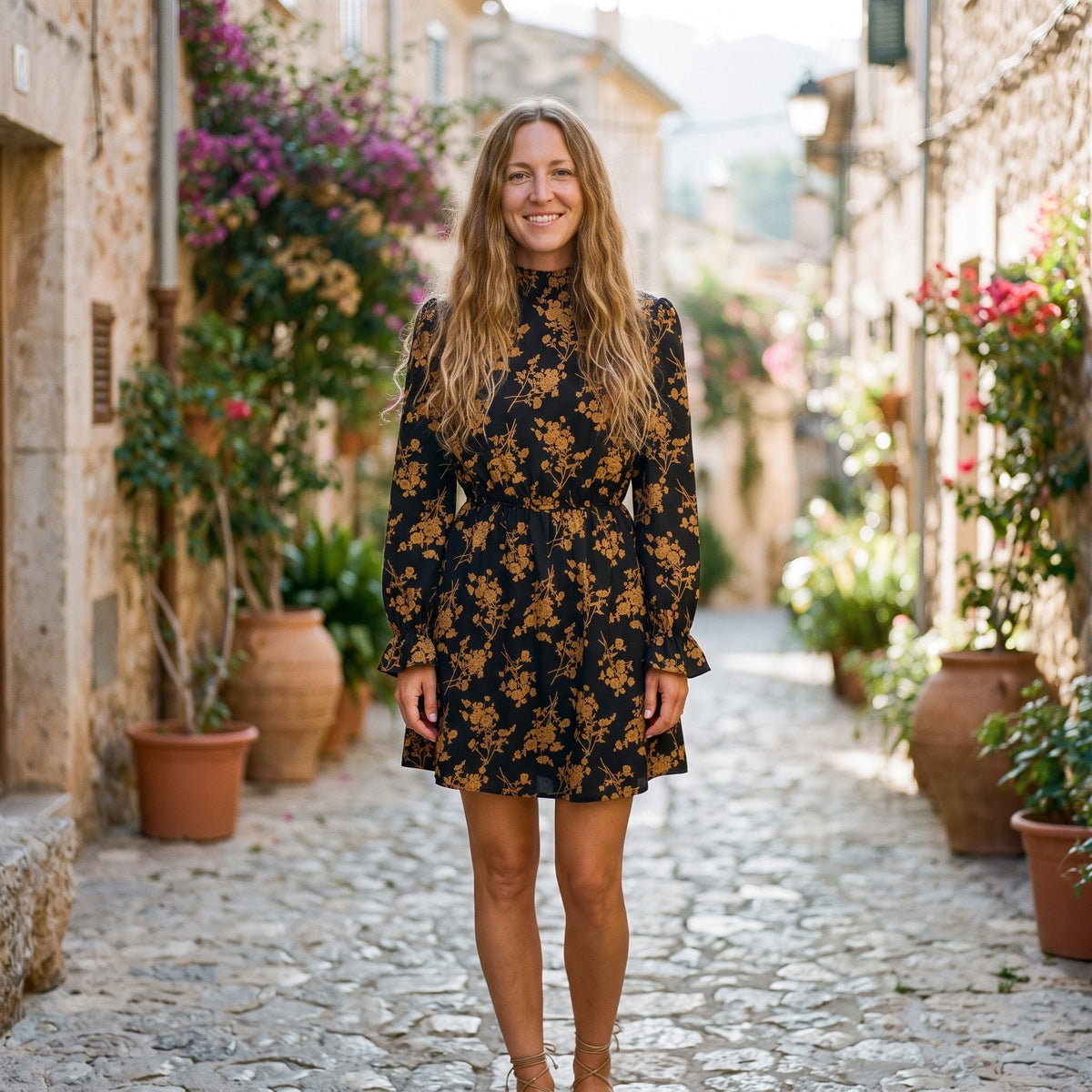 Smiling model wearing the black boho dress with mustard flowers
