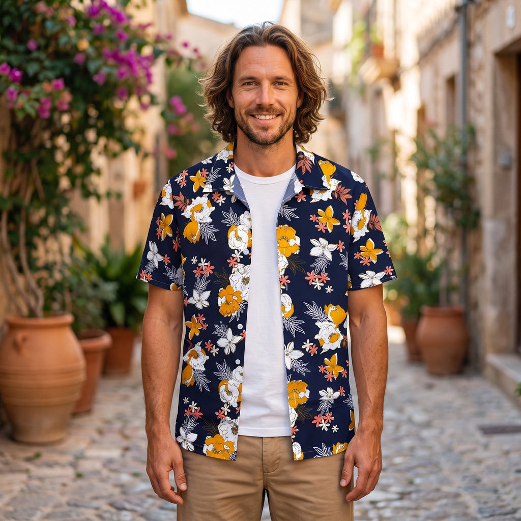 Smiling model wearing a navy floral Hawaiian shirt in a sunny alley
