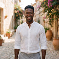 Smiling model wearing the white linen men's hippie shirt in an alley