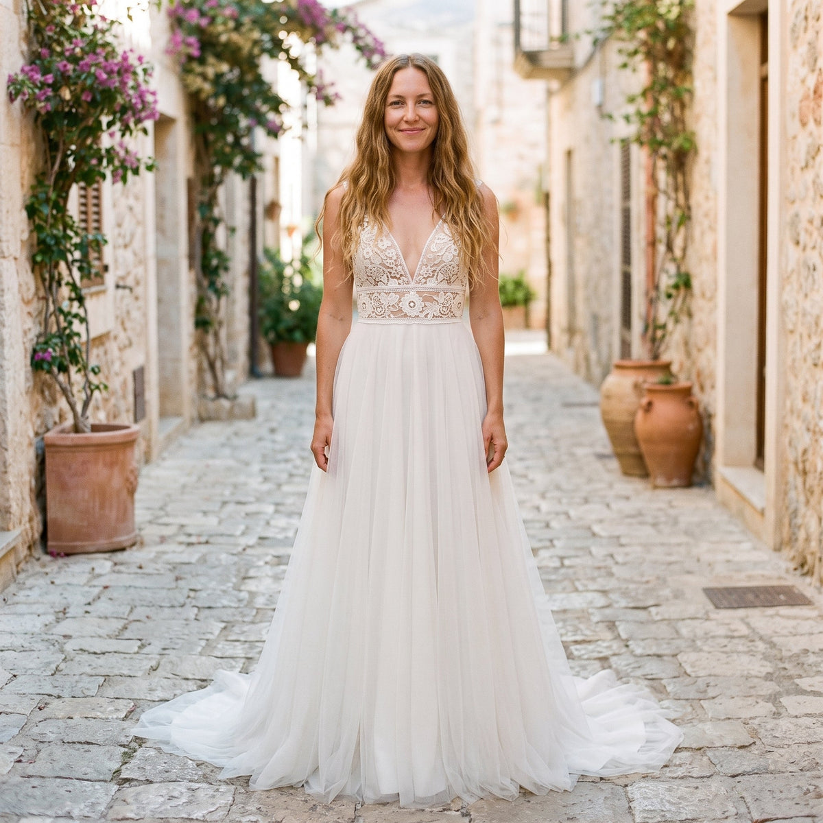 Smiling model wearing tulle boho wedding dress in Mediterranean alley