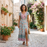 Floral hippie evening dress worn by a smiling model in an alley
