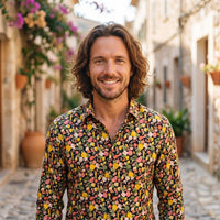 Yellow men's floral hippie shirt worn by a smiling model outdoors