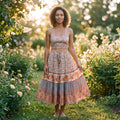 Hymyilevä malli vintage-henkisessä terracotta-kukkaisessa boho-midihameessa puutarhassa