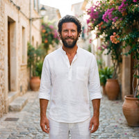 Smiling model wearing the white linen men's hippie shirt in an alley