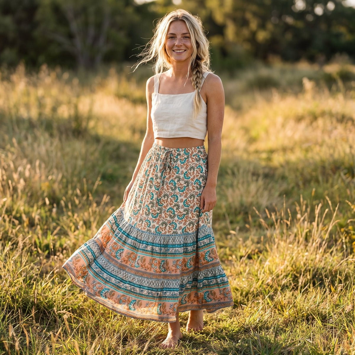 Smilende model iført den turkis og koralfarvede blomstrede boho-nederdel udendørs