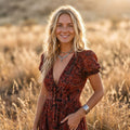 Lächelndes Model im Boho-Maxikleid mit Beinschlitz im Freien